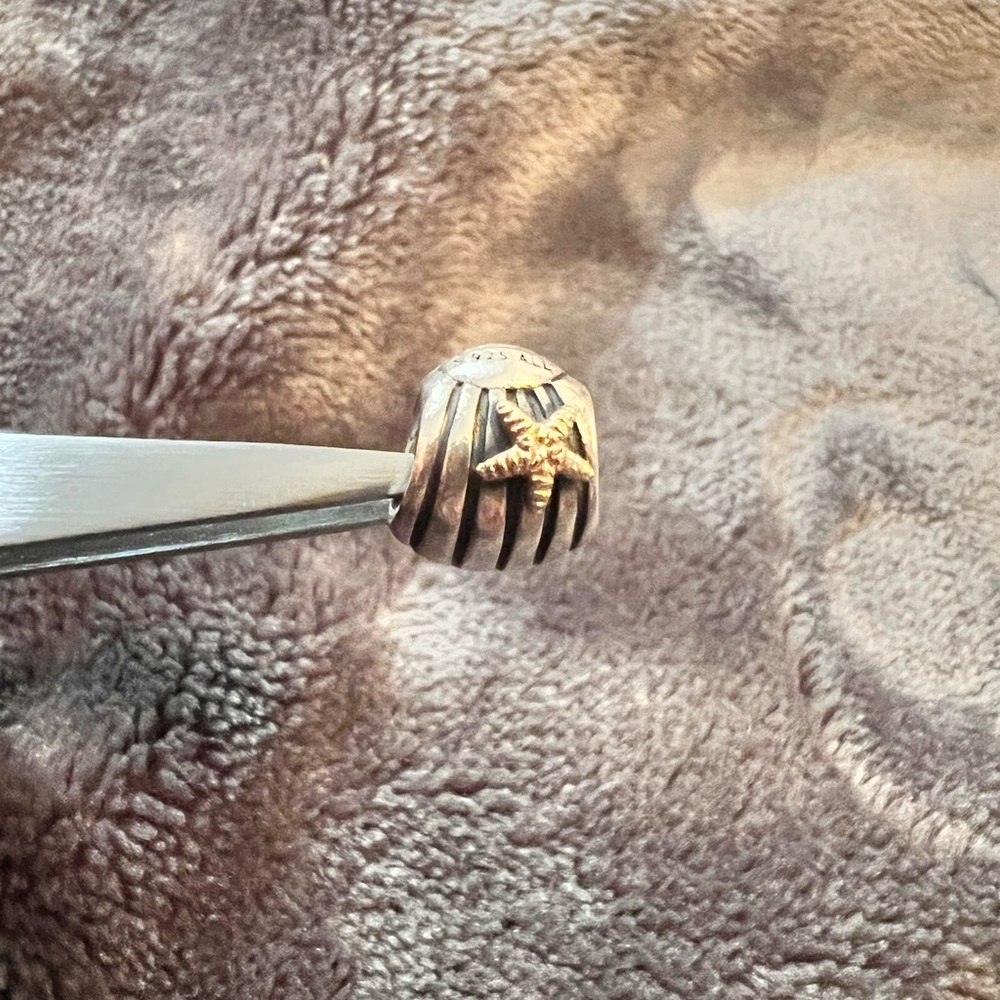 Pandora sterling silver with 14 karat gold seashell with starfish.